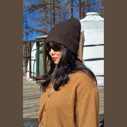 Bonnet en duvet de yak brun foncé en maille côtelée avec large bord replié, accessoire tendance et naturel.